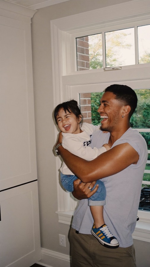 A dad holding his laughing toddler